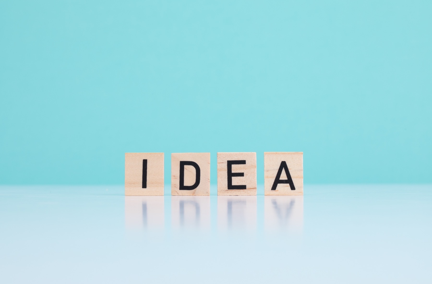 cube en bois gravé du mot IDEA, posé sur un fond neutre