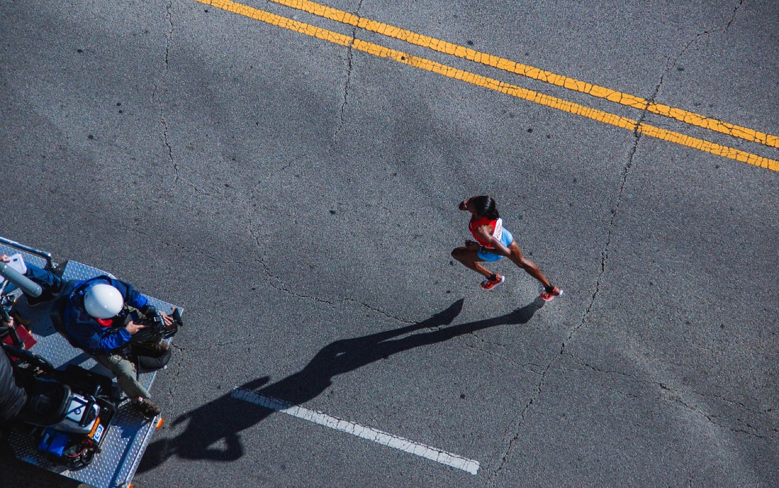 Coureurs massés sur la ligne de départ d'une course sur route, prêts à passer sous l'arche