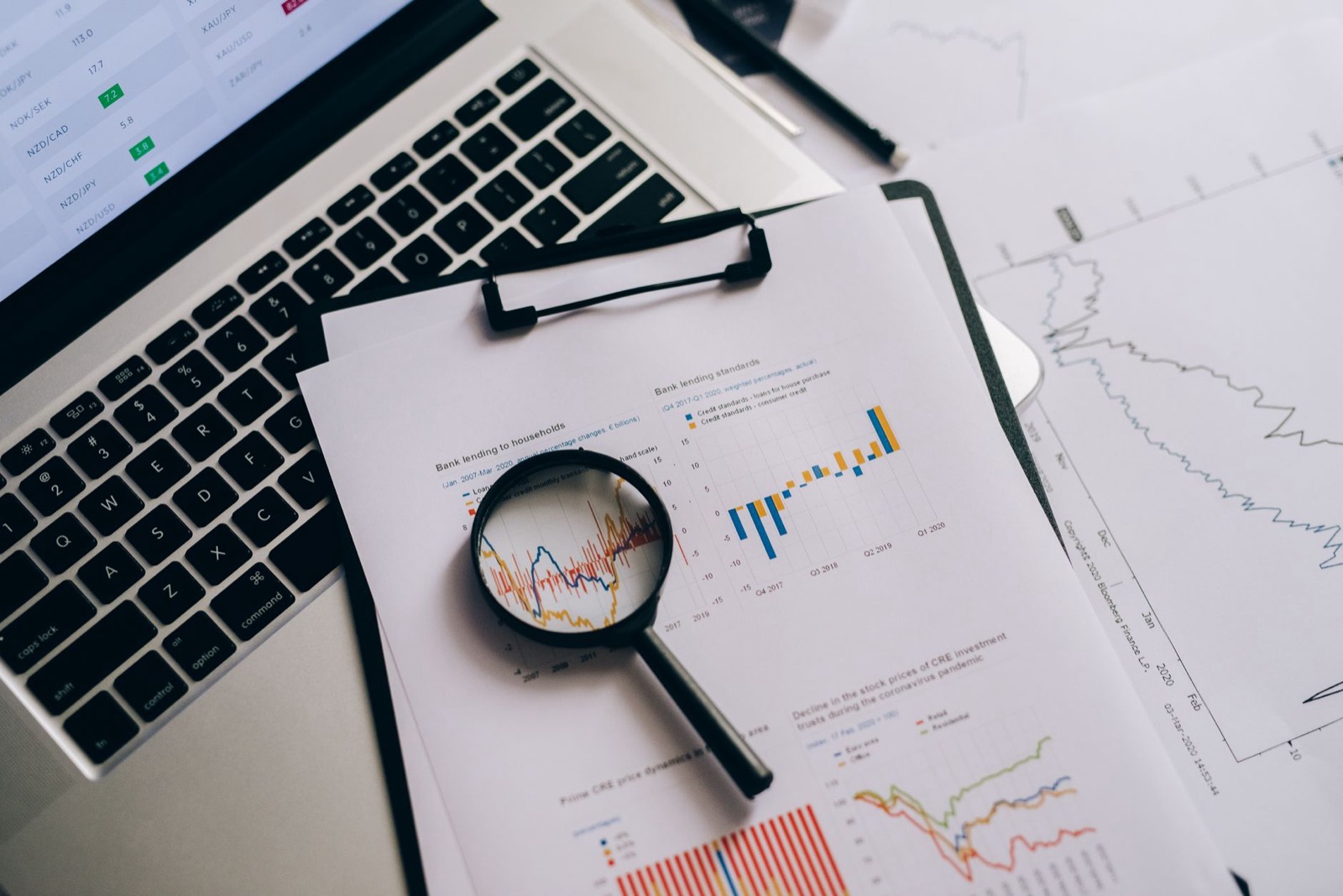 Documents financiers et graphiques sur un bureau pour analyser un fonds d'investissement à impact