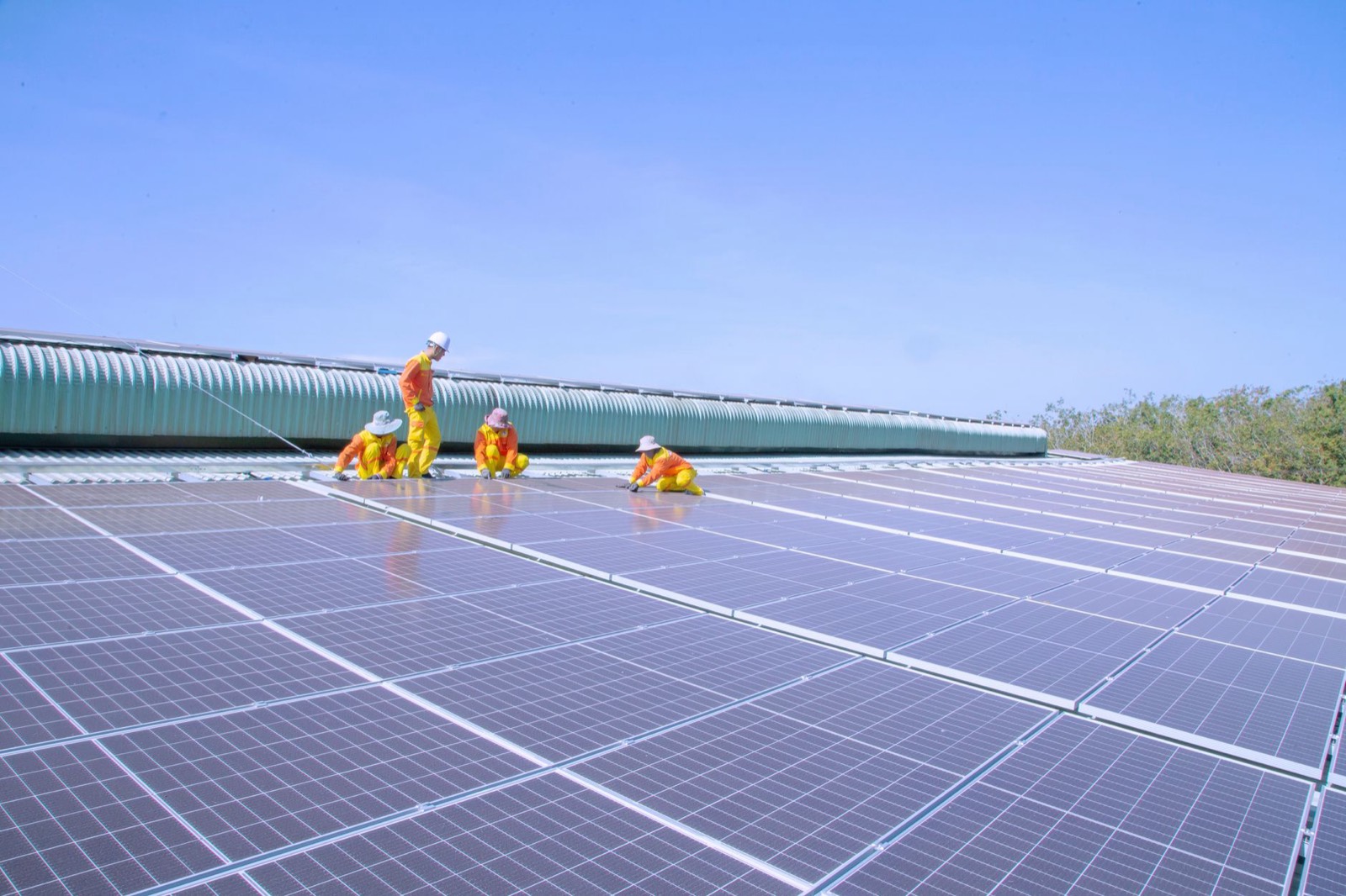 Deux techniciens installent des panneaux solaires sur un toit, exemple de projet financé par l'investissement à impact