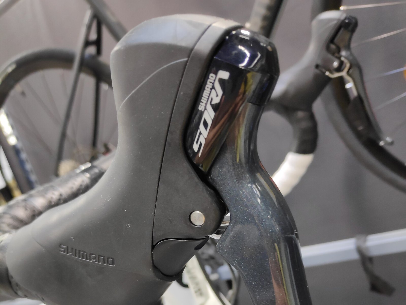 Manette de vitesses et de frein Shimano Sora R3000 montée sur le cintre d'un vélo de route, logo Sora visible
