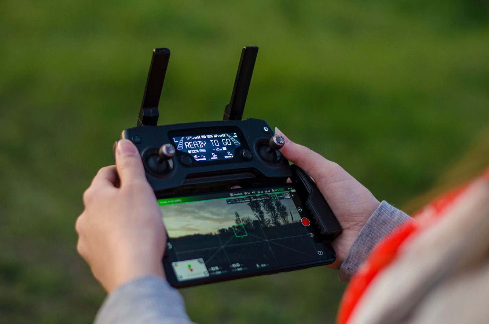 Pilote de drone manipulant sa télécommande en extérieur